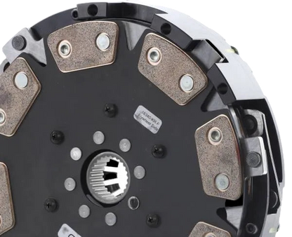 Clutch plate with metallic friction material on a black background